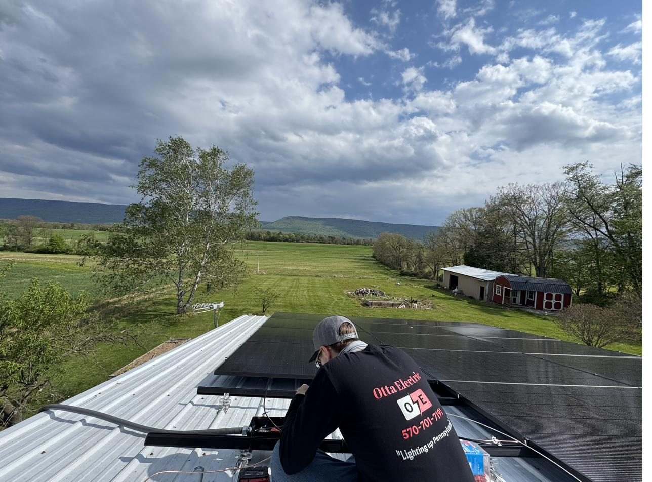 Otta Electric crew installing solar panels on a rooftop in central Pennsylvania